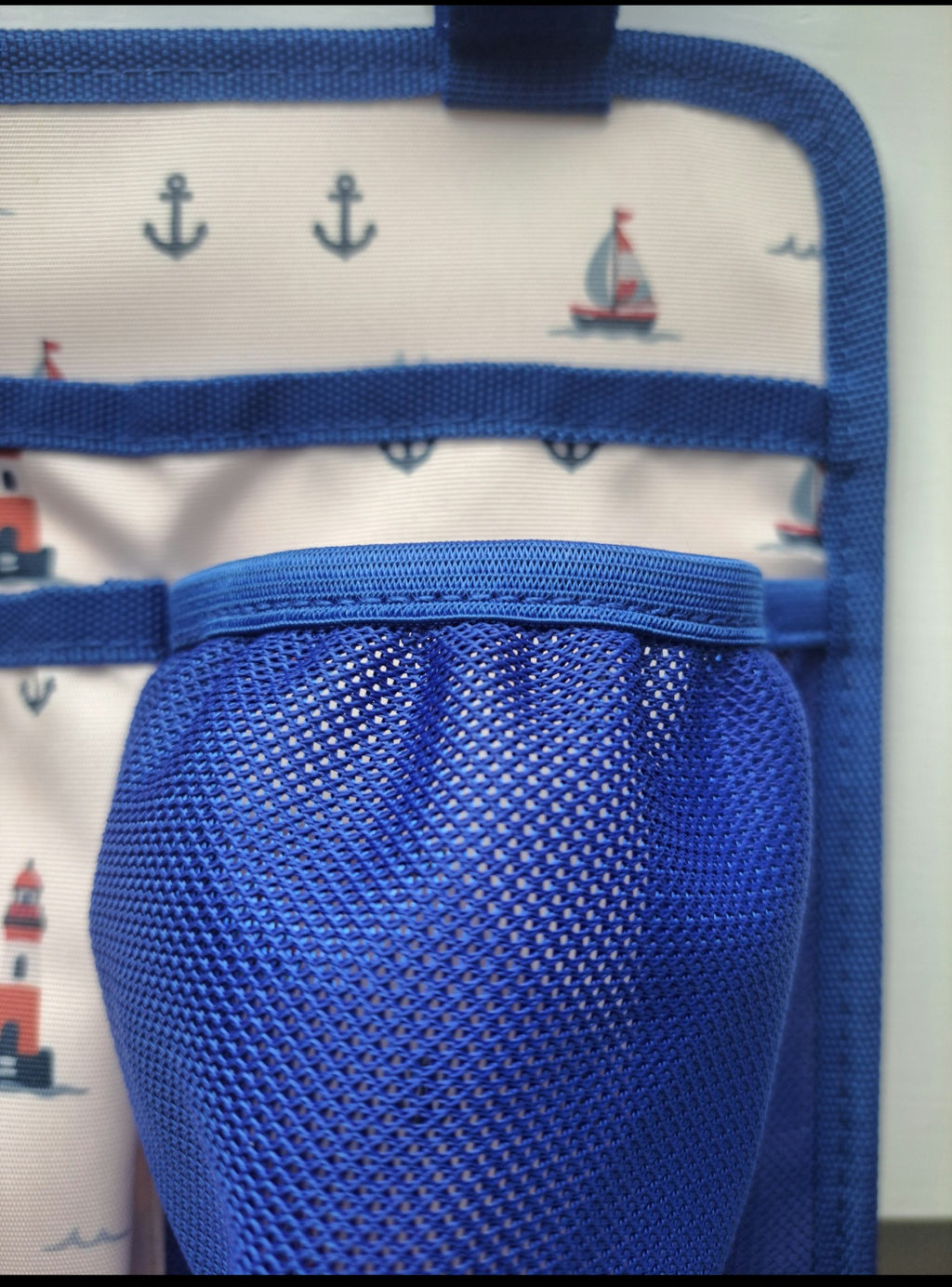 Close-up of Franchi & Ale Bunk Bed Caddy royal blue mesh water bottle holder with nautical print fabric background